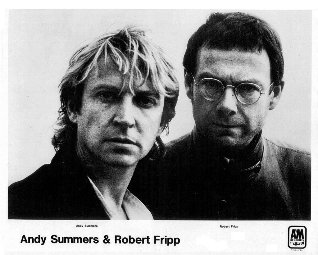 Andy Summers ve Robert Fripp'ın yan yana poz verdiği bir siyah beyaz fotoğraf.